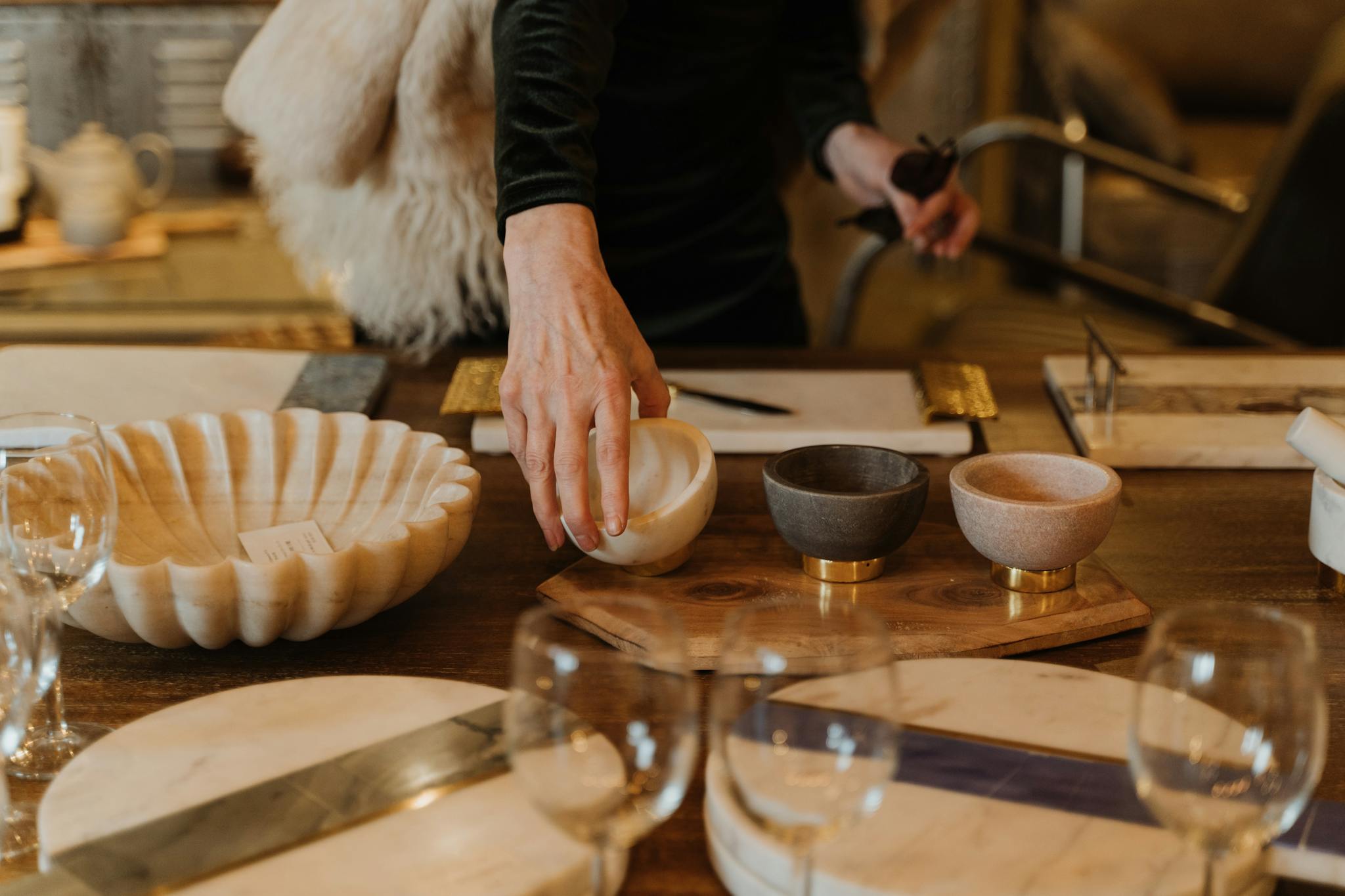 A person selects decorative bowls and tableware in a cozy retail setting.