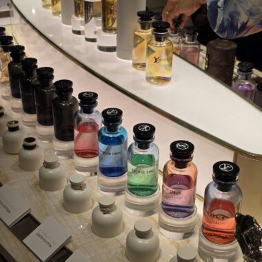 A vibrant display of luxury perfume bottles in various colors and fragrances.