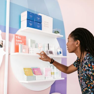 A woman with dreadlocks browsing cosmetics at an upscale salon.