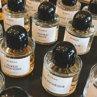 Close-up view of various Byredo perfumes with elegant labels arranged on a shelf.