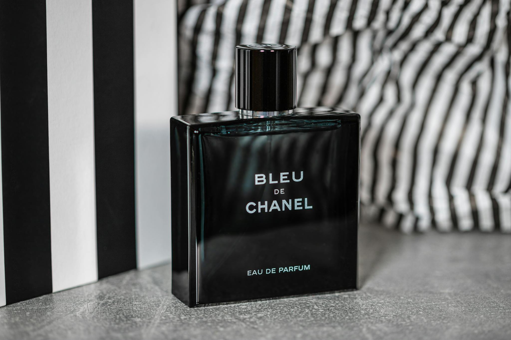 Luxurious Bleu de Chanel perfume bottle showcased with stylish backdrop for product photography.