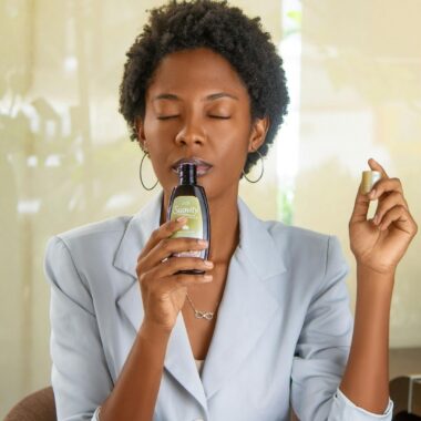 Sophisticated woman indoors relaxing and enjoying the fragrance of a scented product.